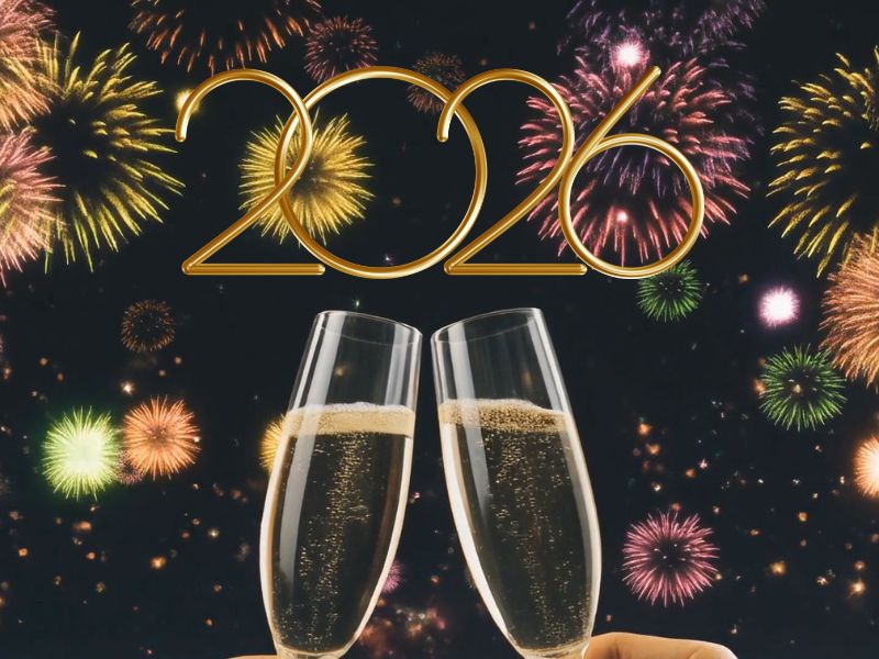 dve osobe nazdravljaju sa šampanjcem, vatromet u pozadini i 2026 godina napisana brojevima